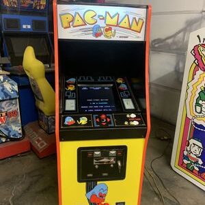 A pac-man arcade machine sitting in the middle of a room.
