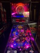 Neon lit arcade pinball machine with colorful playfield