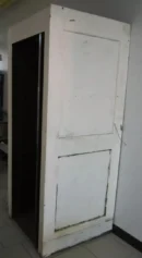 A white door with black trim and a wooden frame.