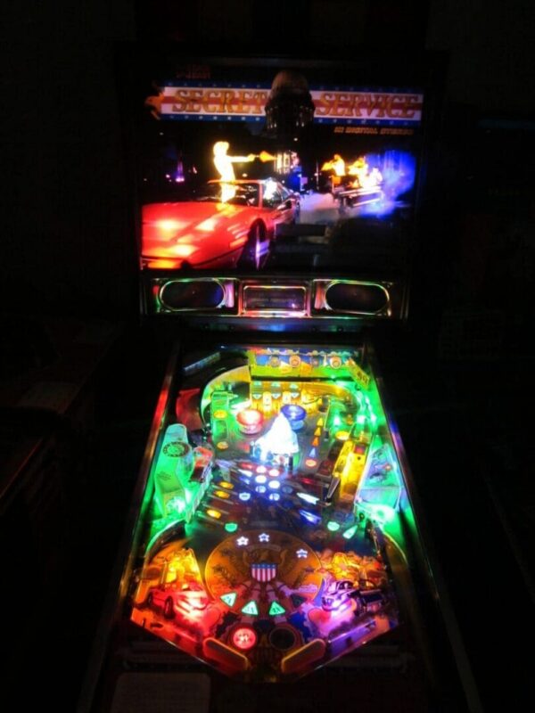 Colorful arcade pinball cabinet lit at night