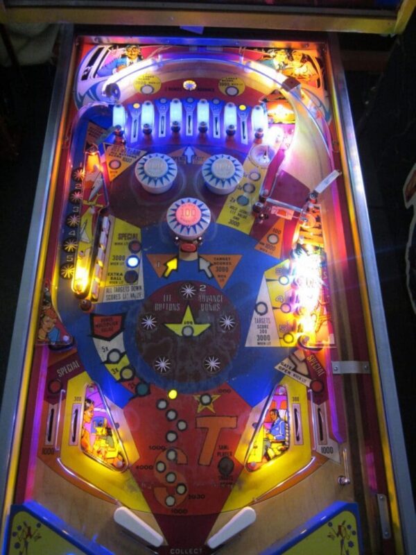 Vintage pinball playfield with lit bumpers