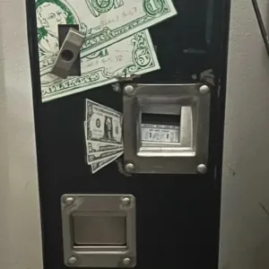 A black machine with money on it.