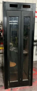 A black metal cabinet with two doors and some glass.