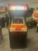 A tetris arcade machine is shown in the dark.